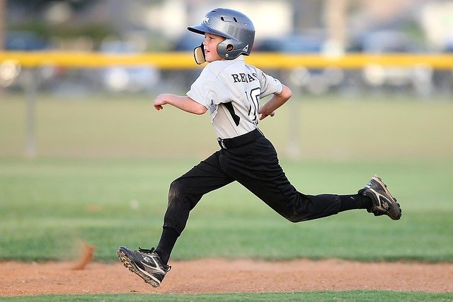 image of boy running between bases on field