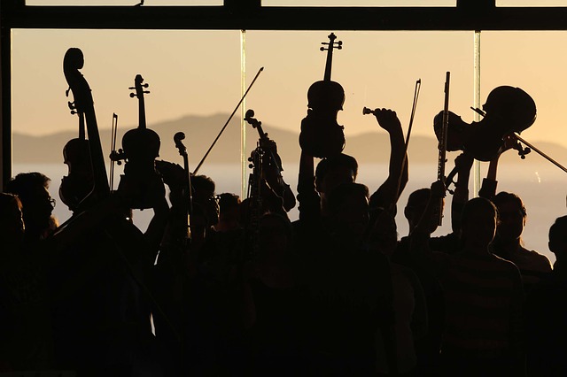 OU Performances & Events image of orchestra players holding up instruments